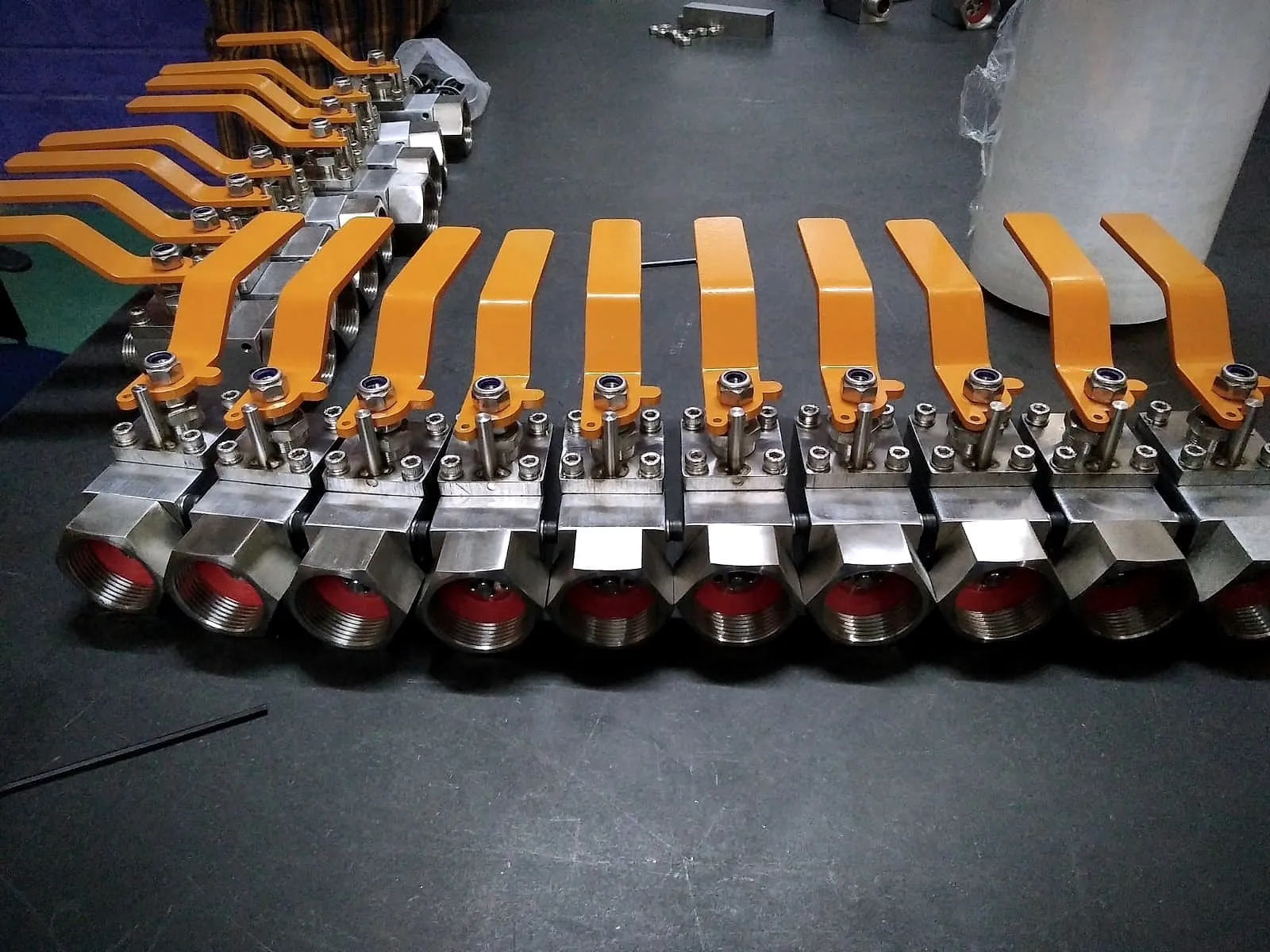 Row of stainless steel ball valves with orange handles