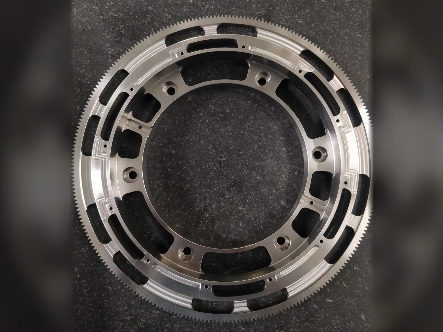 Precision-machined gear ring with fine external teeth, lightening pockets and bolt holes