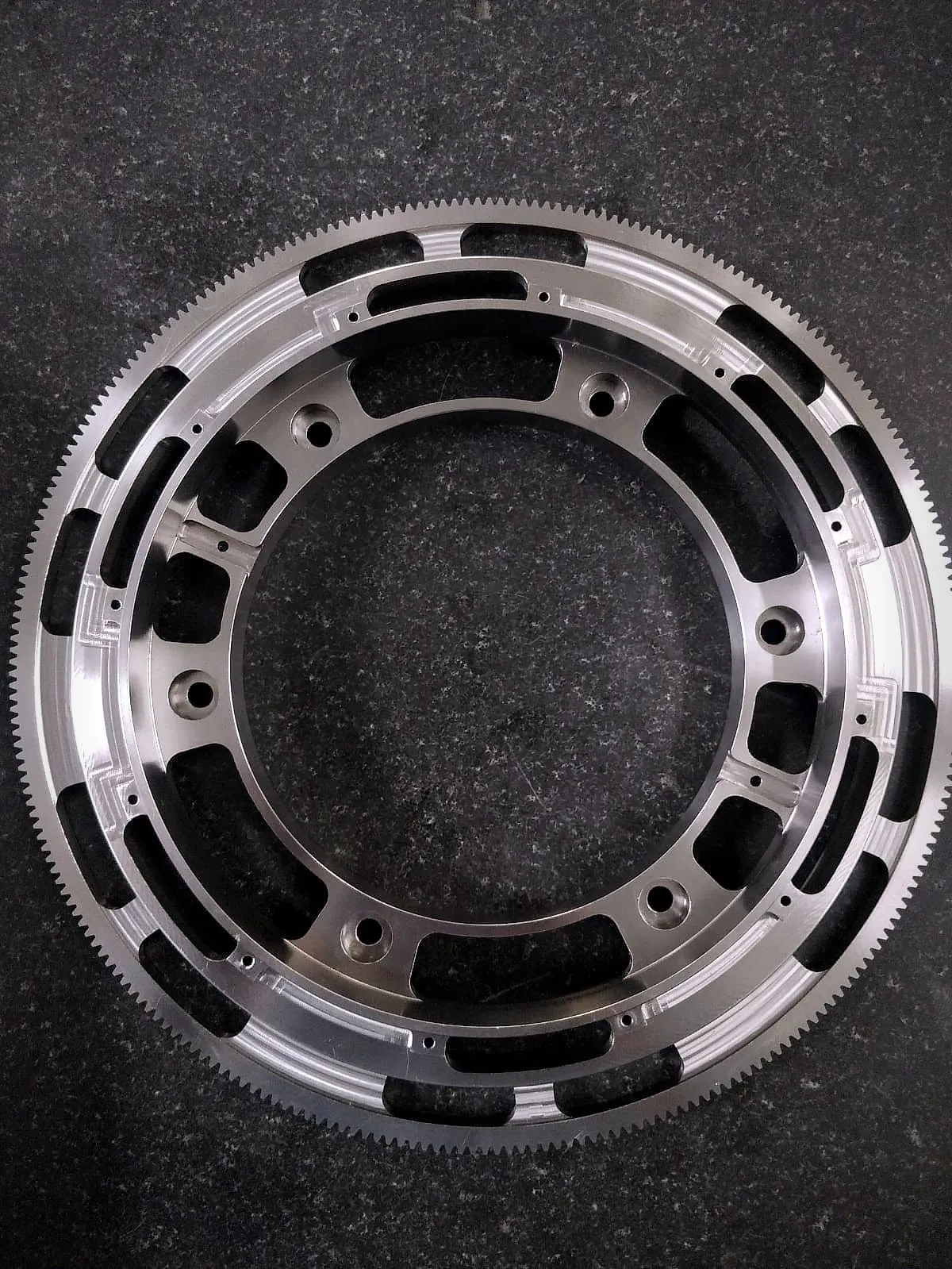 Machined gear ring with fine external teeth, pockets and bolt holes